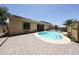 Beautiful backyard with a private pool, brick-paved patio, and lush landscaping for outdoor relaxation at 10414 W Windsor Ave, Avondale, AZ 85392