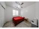 Clean bedroom with tile floors, a ceiling fan, and natural light from the window at 10414 W Windsor Ave, Avondale, AZ 85392