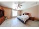 Cozy bedroom with a ceiling fan, tile flooring, and natural light from the window at 10414 W Windsor Ave, Avondale, AZ 85392