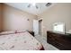 Inviting bedroom with a ceiling fan, tile flooring, and natural light from the window at 10414 W Windsor Ave, Avondale, AZ 85392