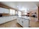 Bright kitchen featuring white cabinets, granite countertops, a kitchen island, and an open floor plan at 10414 W Windsor Ave, Avondale, AZ 85392