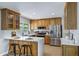 Well-lit kitchen featuring wood cabinetry, stainless steel appliances, and a breakfast bar with white countertops at 1119 W Ellis Dr, Tempe, AZ 85282