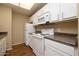 Well-lit kitchen features white cabinetry, appliances and speckled countertops at 11375 E Sahuaro Dr # 1055, Scottsdale, AZ 85259