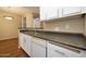 Kitchen features stainless steel sink, white cabinetry and appliances with wood-look flooring at 11375 E Sahuaro Dr # 1055, Scottsdale, AZ 85259