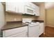 Well-lit kitchen features white cabinetry, appliances and speckled countertops at 11375 E Sahuaro Dr # 1055, Scottsdale, AZ 85259