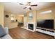 Open-concept living room with wood floors, a fireplace, ceiling fan, and breakfast bar at 11375 E Sahuaro Dr # 1055, Scottsdale, AZ 85259