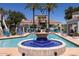 Community pool featuring decorative fountain, blue umbrellas, and lounge chairs at 11375 E Sahuaro Dr # 1055, Scottsdale, AZ 85259