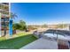 Inviting hot tub area with an outdoor shower, astroturf, and a relaxing lake view at 120 E Rio Salado Pkwy # 101, Tempe, AZ 85281