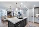 Open-concept kitchen featuring an island with a black base, quartz countertop, and pendant lighting, flowing into the living space at 120 E Rio Salado Pkwy # 101, Tempe, AZ 85281