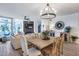 Bright living room with a fireplace, mounted TV, large windows, and dining area with an elegant chandelier at 120 E Rio Salado Pkwy # 101, Tempe, AZ 85281