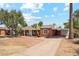Charming brick home with mature landscaping, carport, and driveway on a sunny day at 1238 E Cambridge Ave, Phoenix, AZ 85006