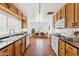 Charming kitchen featuring wooden cabinets, black countertops, and modern appliances, with an open view into the dining area at 1238 E Cambridge Ave, Phoenix, AZ 85006