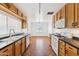Charming kitchen featuring wooden cabinets, black countertops, and modern appliances, with an open view into the dining area at 1238 E Cambridge Ave, Phoenix, AZ 85006