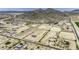 Wide aerial shot featuring a horse property with paddocks, surrounded by desert landscape and distant mountains at 13050 N Breeze Way, Maricopa, AZ 85139