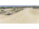 Aerial view showcasing multiple horse shelters on a sandy property at 13050 N Breeze Way, Maricopa, AZ 85139