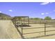 Angle of the horse stalls with metal roofing and fencing and a dirt plot at 13050 N Breeze Way, Maricopa, AZ 85139