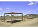 Close-up of the horse stalls, showcasing metal roofing, metal posts, and fencing at 13050 N Breeze Way, Maricopa, AZ 85139
