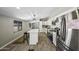 Nicely updated kitchen featuring white cabinets, stainless appliances, quartz counters and island with stool seating at 13050 N Breeze Way, Maricopa, AZ 85139