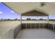 Covered patio offering outdoor living space with views of the large, fenced-in sandy yard at 13050 N Breeze Way, Maricopa, AZ 85139