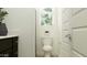 Bright bathroom featuring a toilet, dark vanity, window, and modern fixtures at 14949 W Cottontail Ln, Surprise, AZ 85387