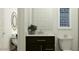 Clean bathroom with a dark vanity, round mirror, and minimalist decor for a modern feel at 14949 W Cottontail Ln, Surprise, AZ 85387