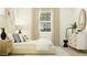 Bright bedroom features white furniture, chic decor, and a light-filled window at 14949 W Cottontail Ln, Surprise, AZ 85387