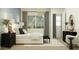 Stylish bedroom with a plush bed, black nightstands, natural lighting, and calming decor at 14949 W Cottontail Ln, Surprise, AZ 85387