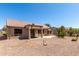 Property backyard featuring covered patio, desert rock ground cover, and surrounding landscaping at 15874 W Wildflower Dr, Surprise, AZ 85374