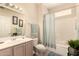 Neutral bathroom with tiled floors, single sink vanity, toilet, and bathtub with shower at 15874 W Wildflower Dr, Surprise, AZ 85374