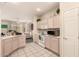 Bright kitchen features tiled floors, white appliances, and ample cabinet space with views into the living room at 15874 W Wildflower Dr, Surprise, AZ 85374