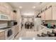 Functional kitchen featuring white appliances and cabinetry, offering a view into the adjacent dining area at 15874 W Wildflower Dr, Surprise, AZ 85374