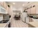 Well-lit kitchen with tiled flooring features white appliances, cabinetry, and a dining area at 15874 W Wildflower Dr, Surprise, AZ 85374