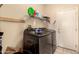 Bright laundry room with sleek, modern, black washer and dryer and convenient shelving at 15874 W Wildflower Dr, Surprise, AZ 85374