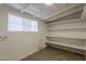 Basement area with open shelves, tile floors, and painted block walls, useful for storage at 1616 E Pecan Rd, Phoenix, AZ 85040