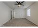 Bright, carpeted bedroom features a ceiling fan, window, and closet at 1616 E Pecan Rd, Phoenix, AZ 85040