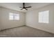 Bright bedroom with carpet, two windows, and ceiling fan, offering a blank canvas for personalization at 1616 E Pecan Rd, Phoenix, AZ 85040