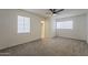 Cozy bedroom features plush carpet, ceiling fan, and ample natural light from two windows at 1616 E Pecan Rd, Phoenix, AZ 85040