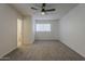 This bright bedroom features a ceiling fan, two large windows, and neutral carpet at 1616 E Pecan Rd, Phoenix, AZ 85040