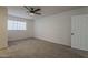 This spacious bedroom features plush carpet, a window, and a ceiling fan at 1616 E Pecan Rd, Phoenix, AZ 85040