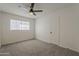 This minimalist bedroom features a ceiling fan, large window, and plush carpet at 1616 E Pecan Rd, Phoenix, AZ 85040