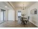 The dining room features wood-look tile floors, a round wooden table, and a modern chandelier, creating a warm ambiance at 1616 E Pecan Rd, Phoenix, AZ 85040