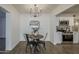 Dining room features modern lighting, wood-look floors, a round table, and seamlessly connects to a kitchen with stainless appliances at 1616 E Pecan Rd, Phoenix, AZ 85040