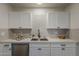 A modern kitchen is shown featuring white cabinets, neutral subway tile backsplash, stainless steel appliances, and quartz countertops at 1616 E Pecan Rd, Phoenix, AZ 85040
