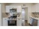 A kitchen features stainless steel appliances, quartz countertops, white shaker cabinets, and a complementing neutral backsplash at 1616 E Pecan Rd, Phoenix, AZ 85040
