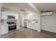 An open kitchen showcases stainless appliances, white cabinets, and wood-look tile floors, complemented by neutral subway tile backsplash at 1616 E Pecan Rd, Phoenix, AZ 85040