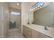 Bright bathroom featuring a shower, and a vanity with generous counter space and attractive decor and vanity lighting at 16354 W Labyrinth Ln, Surprise, AZ 85374