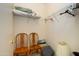 Walk-in closet with wire shelving, storage containers, and wooden chairs at 16354 W Labyrinth Ln, Surprise, AZ 85374