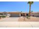 Charming single-story home featuring a desert landscape, two-car garage, and a beautiful palm tree on a sunny day at 16354 W Labyrinth Ln, Surprise, AZ 85374