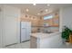Bright kitchen featuring light wood cabinets and a white countertop breakfast bar at 16354 W Labyrinth Ln, Surprise, AZ 85374