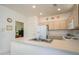 Kitchen featuring a breakfast bar, light wood cabinets, and white appliances at 16354 W Labyrinth Ln, Surprise, AZ 85374